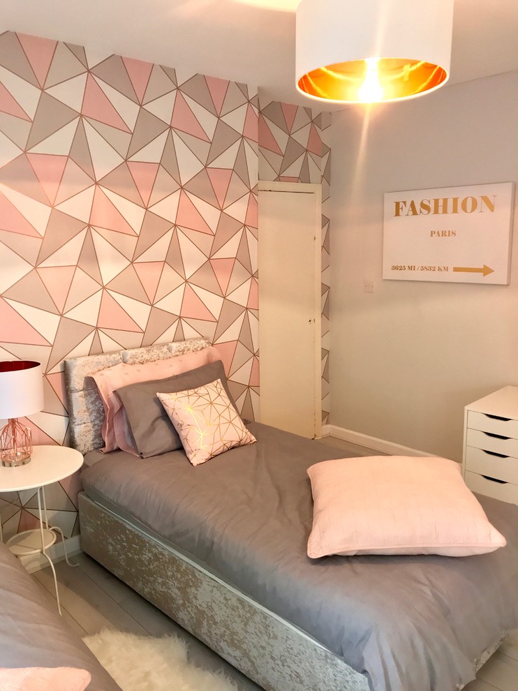 Design ideas for a mid-sized modern kids' room for girls in London with grey walls, laminate floors and white floor.