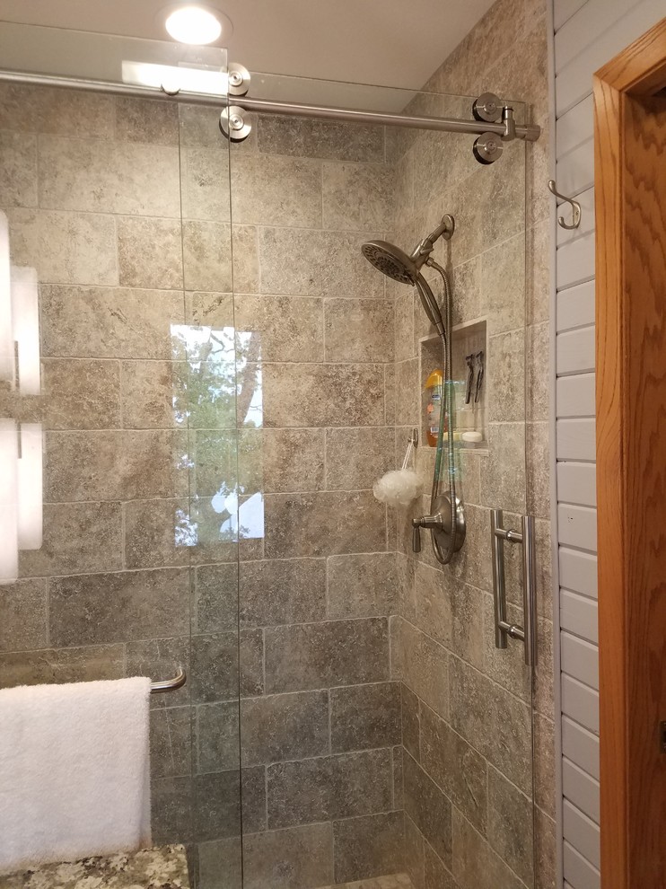 Mid-sized mountain style master gray tile and travertine tile medium tone wood floor and brown floor alcove shower photo with flat-panel cabinets, gray cabinets, a two-piece toilet, gray walls, an undermount sink and granite countertops