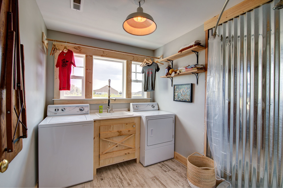 Country single-wall utility room in Other with a drop-in sink, light wood cabinets, grey walls, light hardwood floors, a side-by-side washer and dryer, beige floor and beige benchtop.