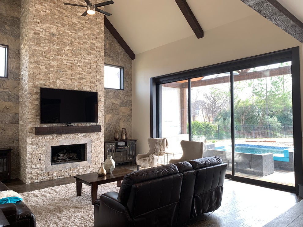 Design ideas for an expansive modern open concept family room in Dallas with beige walls, dark hardwood floors, a standard fireplace, a stone fireplace surround, a wall-mounted tv and brown floor.