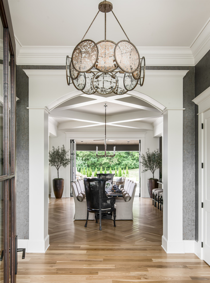Inspiration for a mid-sized transitional foyer in Nashville with blue walls, medium hardwood floors, a single front door, a dark wood front door and wallpaper.