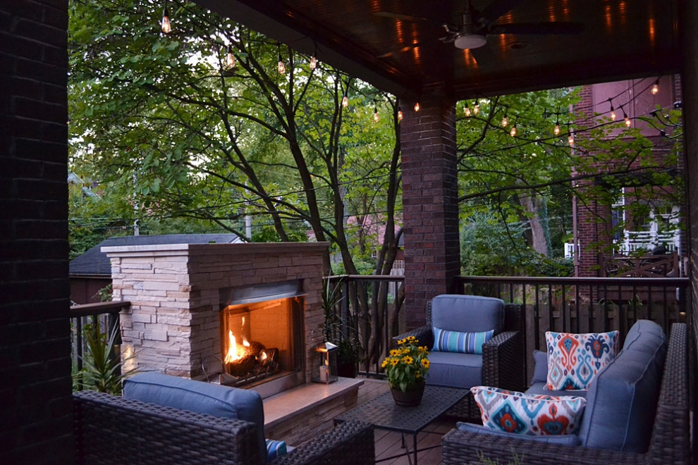 Photo of a mid-sized transitional backyard deck in St Louis with with fireplace and a roof extension.