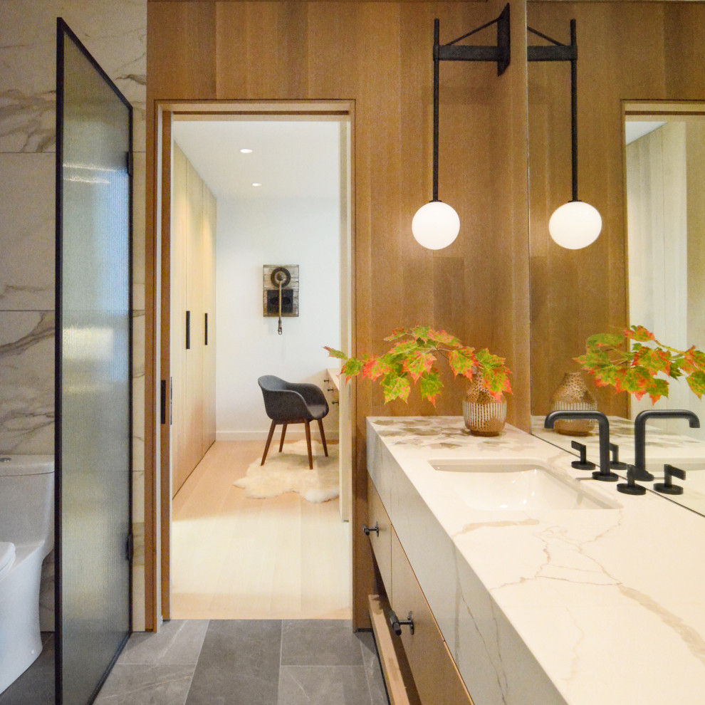 This is an example of a large contemporary master bathroom in Other with flat-panel cabinets, white cabinets, an alcove shower, white tile, marble, brown walls, slate floors, an undermount sink, marble benchtops, grey floor, a hinged shower door, white benchtops, a shower seat, a double vanity, a built-in vanity, wood walls and a one-piece toilet.