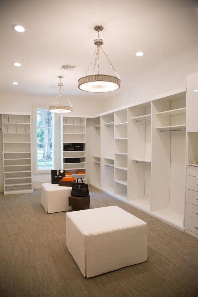 This is an example of a mid-sized modern gender-neutral walk-in wardrobe in Los Angeles with flat-panel cabinets, white cabinets and carpet.