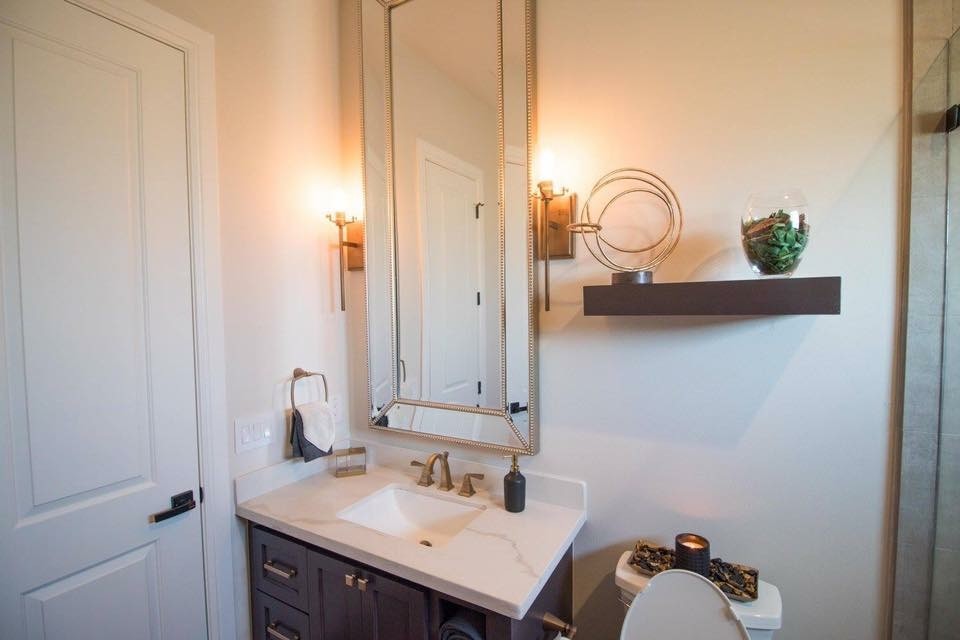 Mid-sized transitional 3/4 medium tone wood floor and brown floor bathroom photo with shaker cabinets, dark wood cabinets, a two-piece toilet, beige walls, an undermount sink and quartz countertops