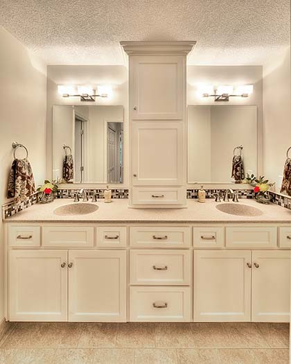 Mid-sized transitional master bathroom in Kansas City with an integrated sink, recessed-panel cabinets, white cabinets, onyx benchtops, an alcove shower, a two-piece toilet, multi-coloured tile, glass tile, white walls and porcelain floors.