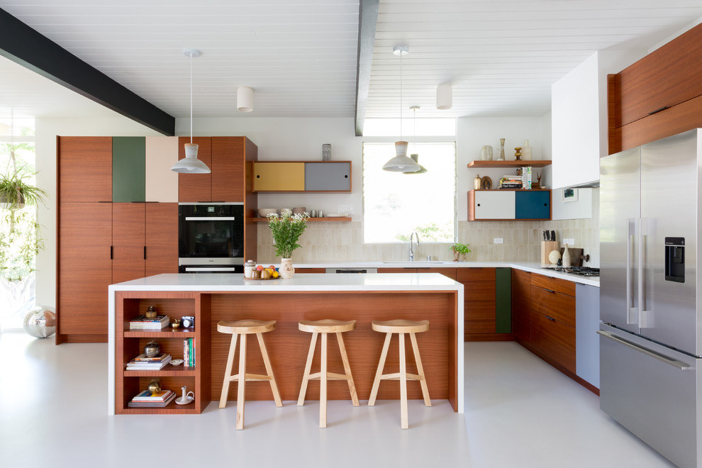 Mid-sized midcentury l-shaped open plan kitchen in Los Angeles with flat-panel cabinets, medium wood cabinets, quartz benchtops and with island.