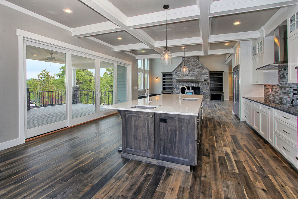 Example of a large transitional galley dark wood floor open concept kitchen design in Denver with an undermount sink, recessed-panel cabinets, gray cabinets, quartz countertops, gray backsplash, glass tile backsplash, stainless steel appliances and an island