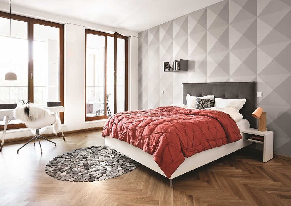 This is an example of a large contemporary bedroom in Dusseldorf with grey walls, medium hardwood floors and no fireplace.
