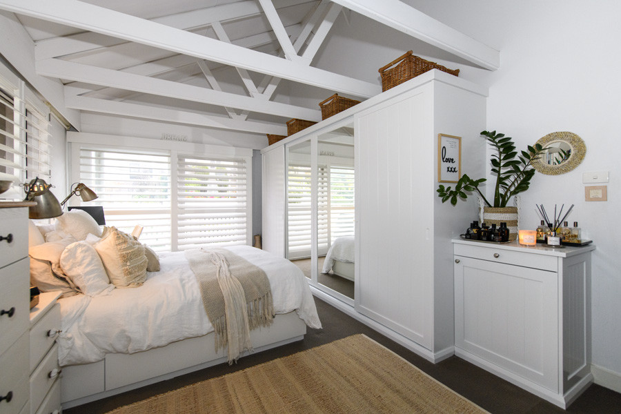 Mid-sized minimalist master dark wood floor bedroom photo in Sydney with white walls