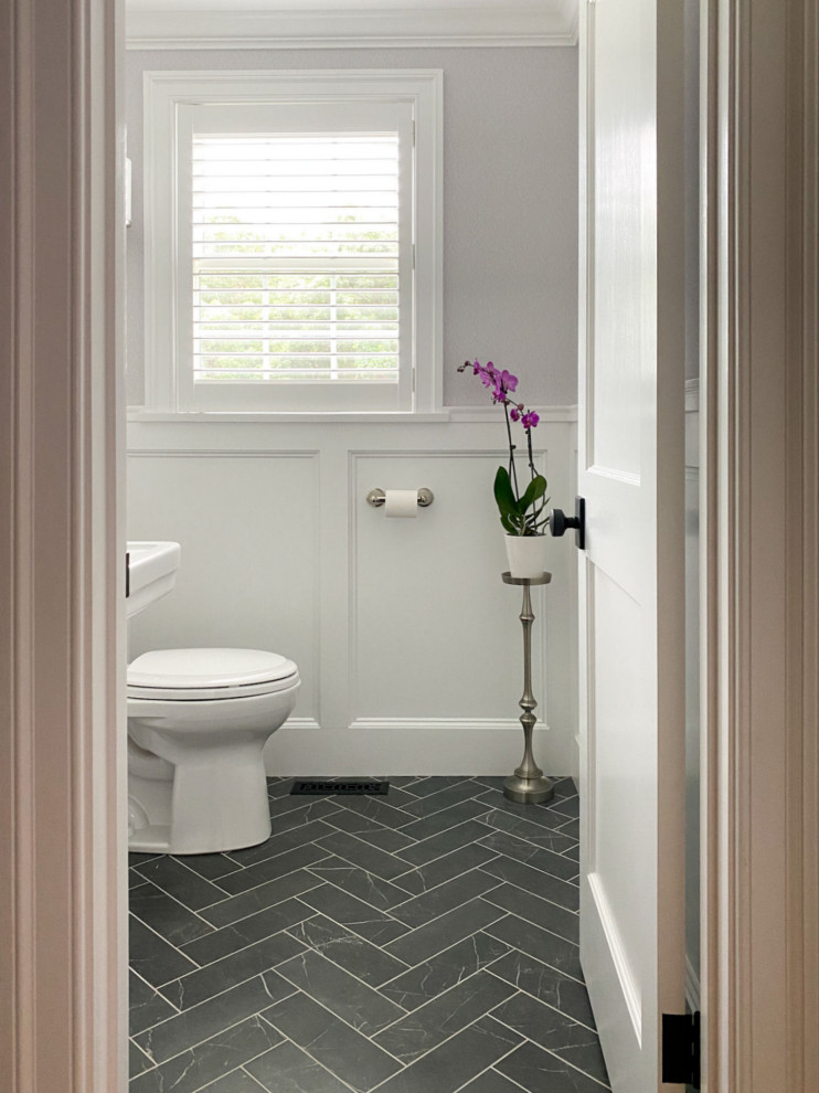 Ispirazione per un bagno di servizio classico con WC a due pezzi, pavimento in gres porcellanato, lavabo a colonna, pavimento nero e carta da parati