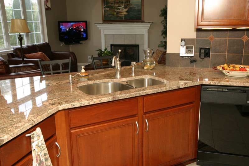 Transitional u-shaped medium tone wood floor kitchen pantry photo in Chicago with raised-panel cabinets, medium tone wood cabinets and granite countertops