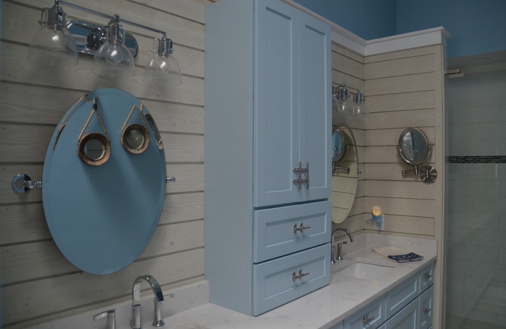 This is an example of a mid-sized beach style master bathroom in Jacksonville with shaker cabinets, blue cabinets, a double shower, a two-piece toilet, white tile, ceramic tile, blue walls, porcelain floors, engineered quartz benchtops, beige floor and a hinged shower door.