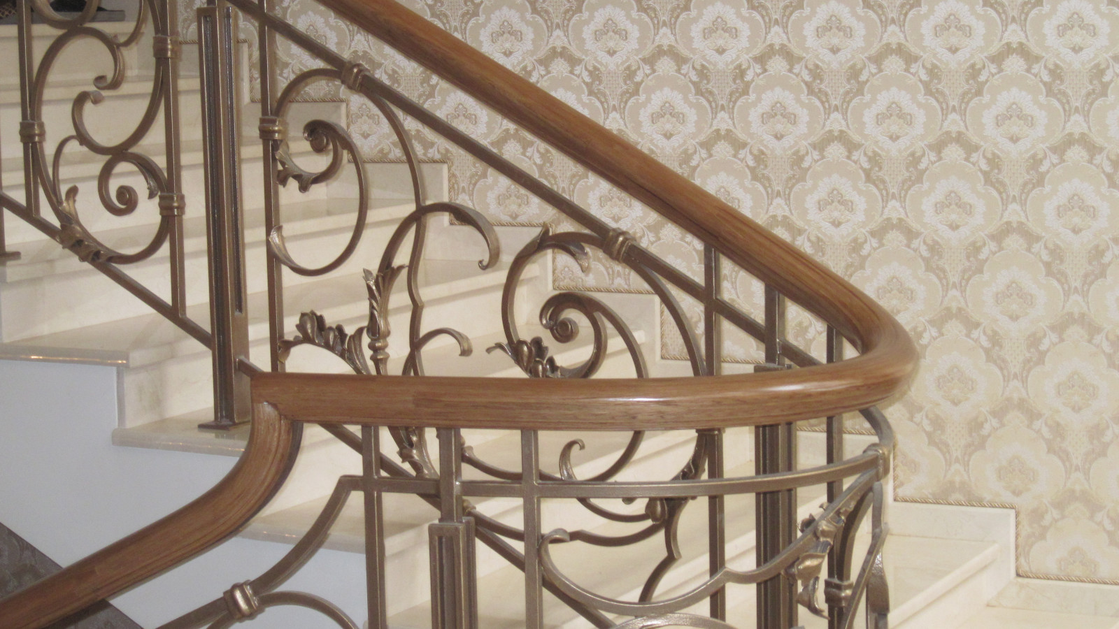 Деревянный гнутый поручень на кованые ограждения лестниц.