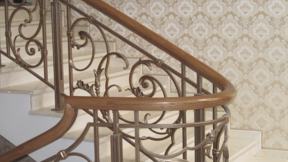 Деревянный гнутый поручень на кованые ограждения лестниц.