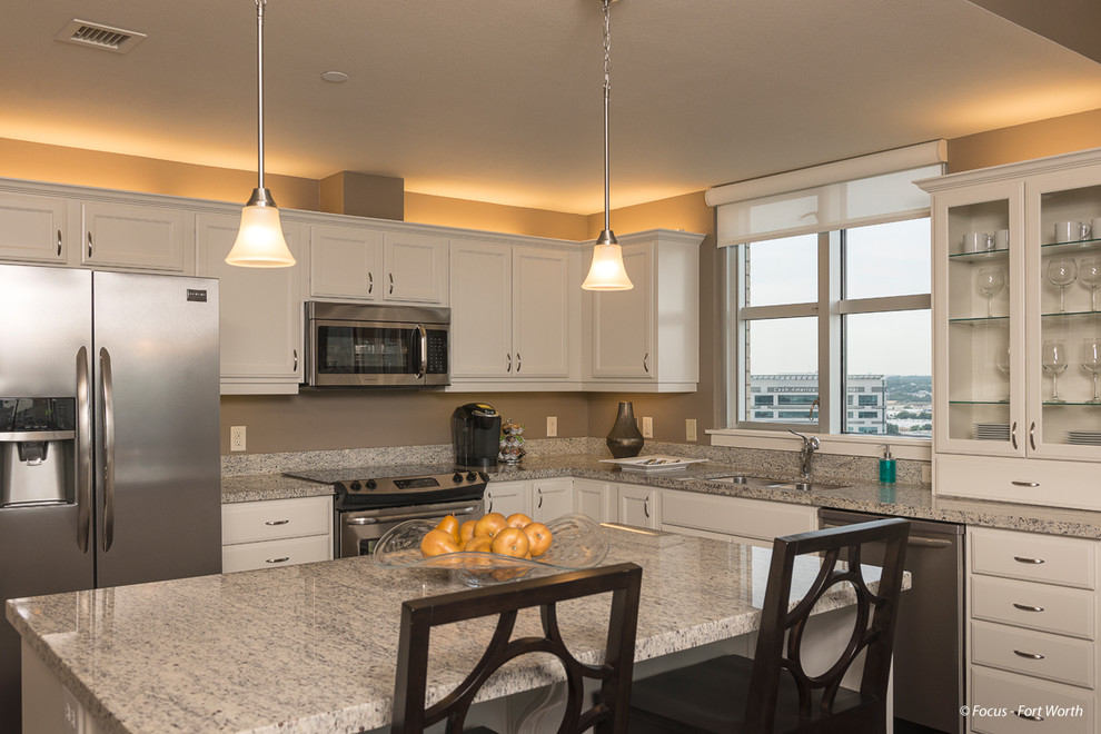 Inspiration for a transitional dark wood floor open concept kitchen remodel in Dallas with an undermount sink, flat-panel cabinets, beige cabinets, granite countertops, stainless steel appliances and an island