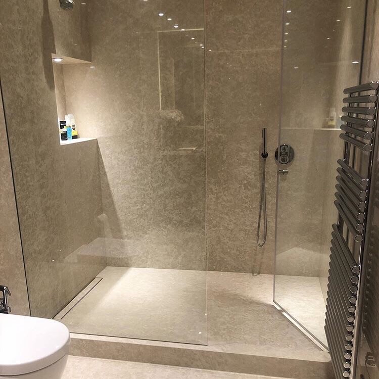 Modern bathroom in London with a double shower, beige tile, marble, beige walls, marble floors, beige floor and a hinged shower door.