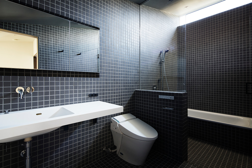 Design ideas for a contemporary bathroom in Tokyo with black tile, an alcove shower, black walls, terra-cotta floors and a trough sink.