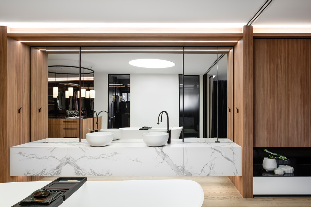 Expansive contemporary master bathroom in Sydney with a freestanding tub, a double shower, medium hardwood floors, a vessel sink, marble benchtops, a hinged shower door, an enclosed toilet, a double vanity and a floating vanity.