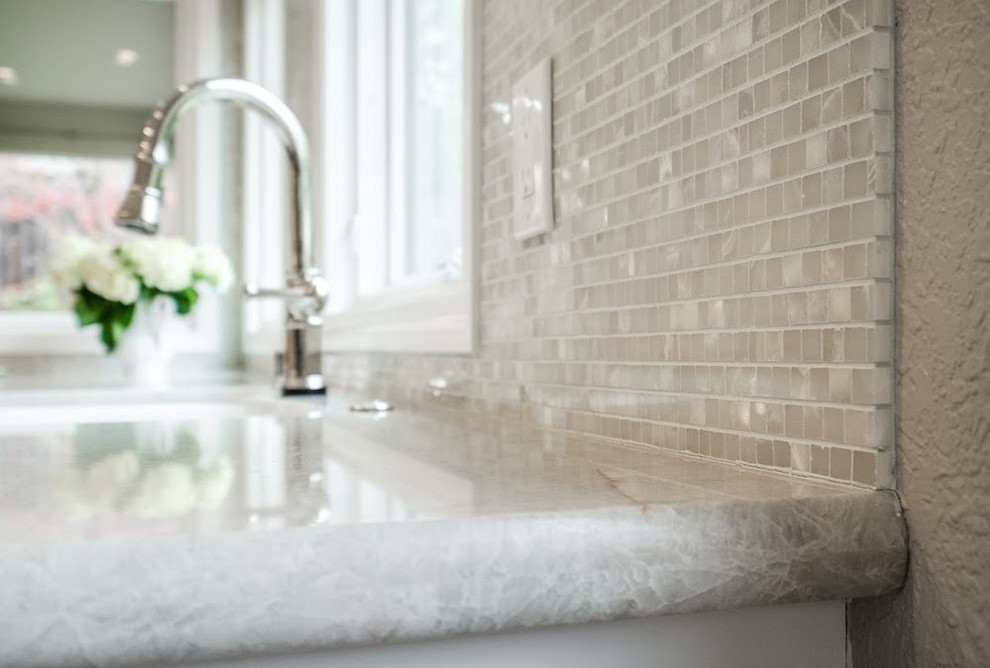 Eat-in kitchen - large transitional u-shaped limestone floor eat-in kitchen idea with an undermount sink, shaker cabinets, white cabinets, marble countertops, metallic backsplash, mosaic tile backsplash, stainless steel appliances and an island