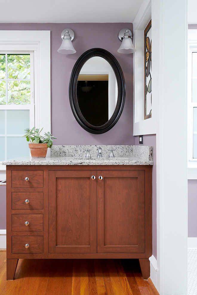 Design ideas for a mid-sized transitional 3/4 bathroom in Philadelphia with shaker cabinets, dark wood cabinets, purple walls, an undermount sink, granite benchtops, brown floor, beige benchtops and medium hardwood floors.
