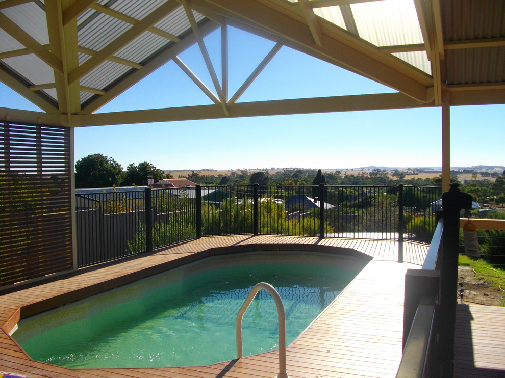 This is an example of a small backyard round aboveground pool in Adelaide with decking.