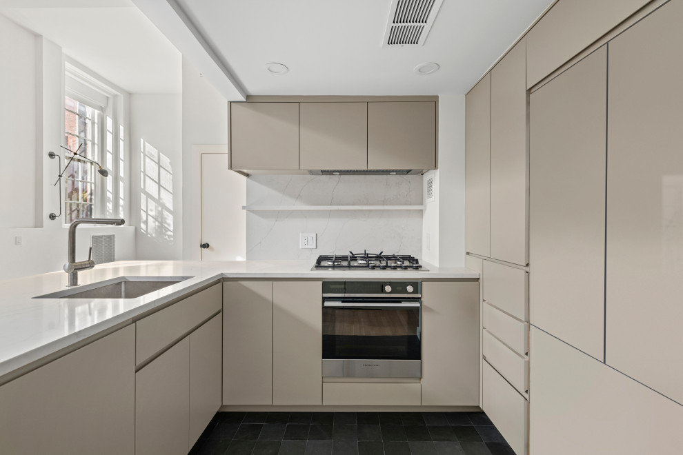 Inspiration för små moderna vitt l-kök, med en nedsänkt diskho, släta luckor, beige skåp, marmorbänkskiva, grått stänkskydd, stänkskydd i marmor, integrerade vitvaror, klinkergolv i keramik, en halv köksö och svart golv