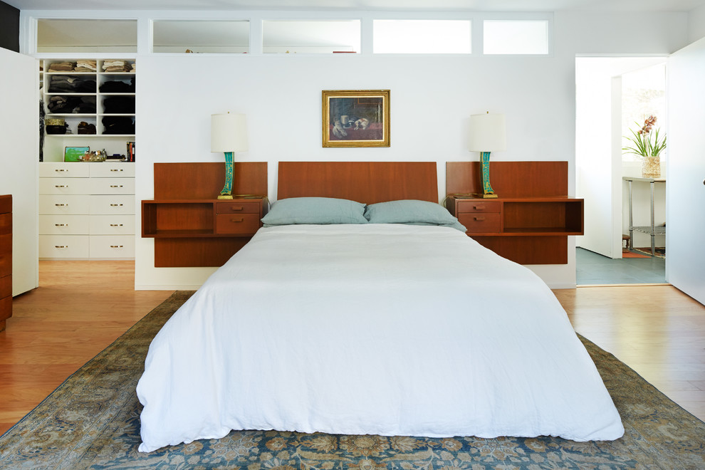 Modern master bedroom in Los Angeles with white walls and medium hardwood floors.