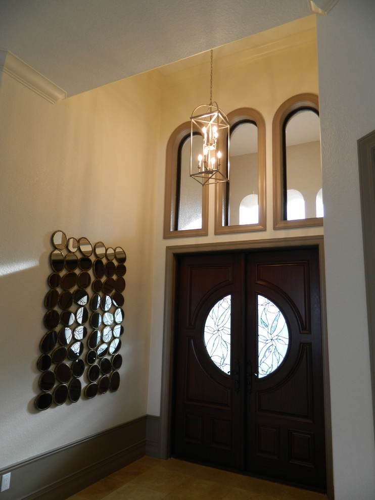 Mid-sized island style travertine floor entryway photo in Tampa with beige walls and a dark wood front door