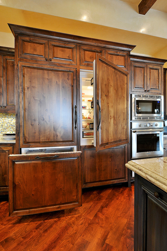 Huge mountain style u-shaped medium tone wood floor eat-in kitchen photo in Austin with a drop-in sink, granite countertops, multicolored backsplash, ceramic backsplash, paneled appliances and an island