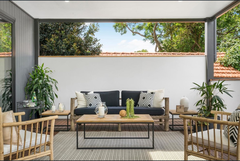 This is an example of a mid-sized contemporary backyard patio in Sydney with decking and a roof extension.