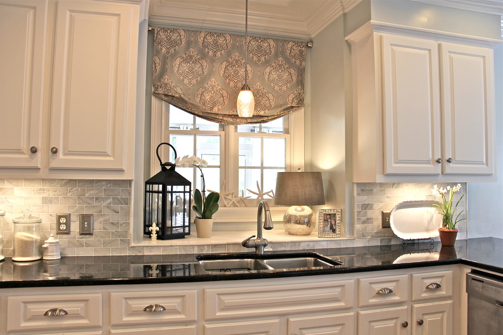 Inspiration for a mid-sized coastal u-shaped medium tone wood floor enclosed kitchen remodel with raised-panel cabinets, white cabinets, granite countertops, white backsplash, subway tile backsplash, stainless steel appliances and an undermount sink