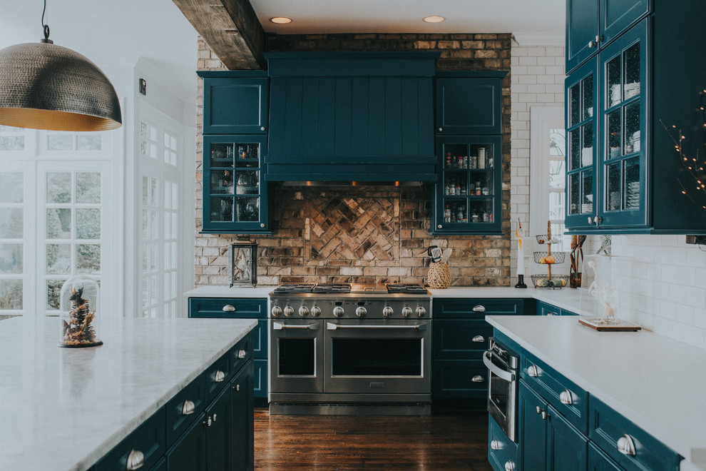 Inspiration for a large eclectic u-shaped eat-in kitchen in Charlotte with a farmhouse sink, flat-panel cabinets, blue cabinets, marble benchtops, white splashback, ceramic splashback, stainless steel appliances, dark hardwood floors, with island and brown floor.
