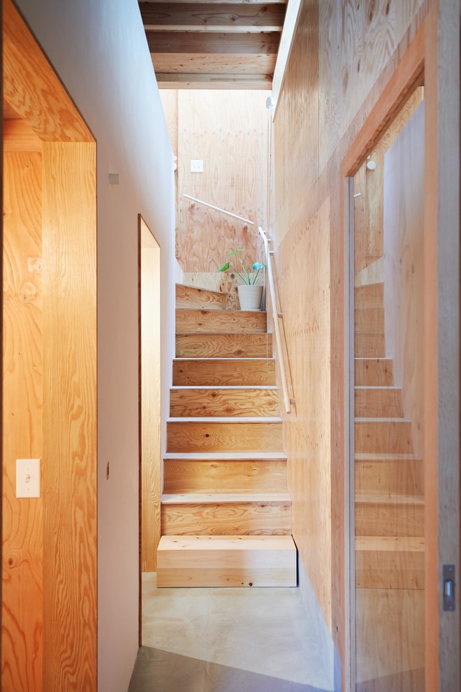 This is an example of a small wood staircase in Tokyo with wood risers and wood railing.