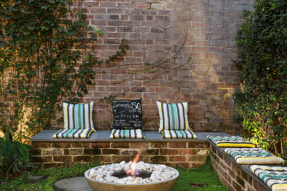 Design ideas for an industrial backyard patio in Sydney with a fire feature.