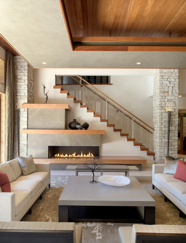 This is an example of an expansive contemporary open concept living room in Minneapolis with beige walls, porcelain floors, a ribbon fireplace, a stone fireplace surround and a wall-mounted tv.