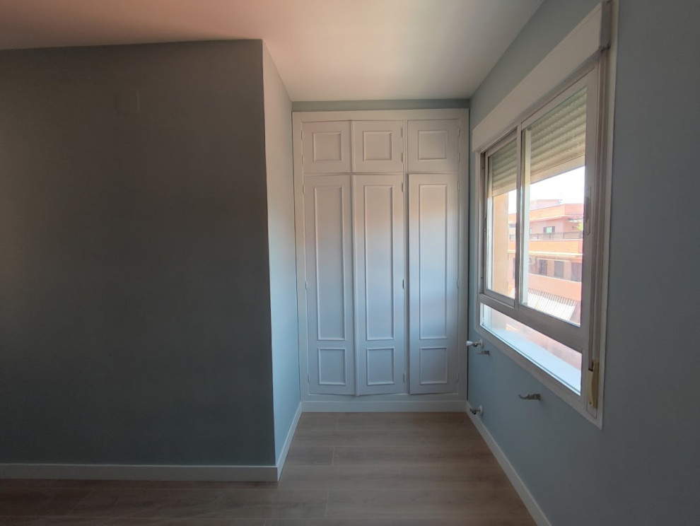 Immagine di una camera matrimoniale design con pareti blu, parquet chiaro e pavimento marrone