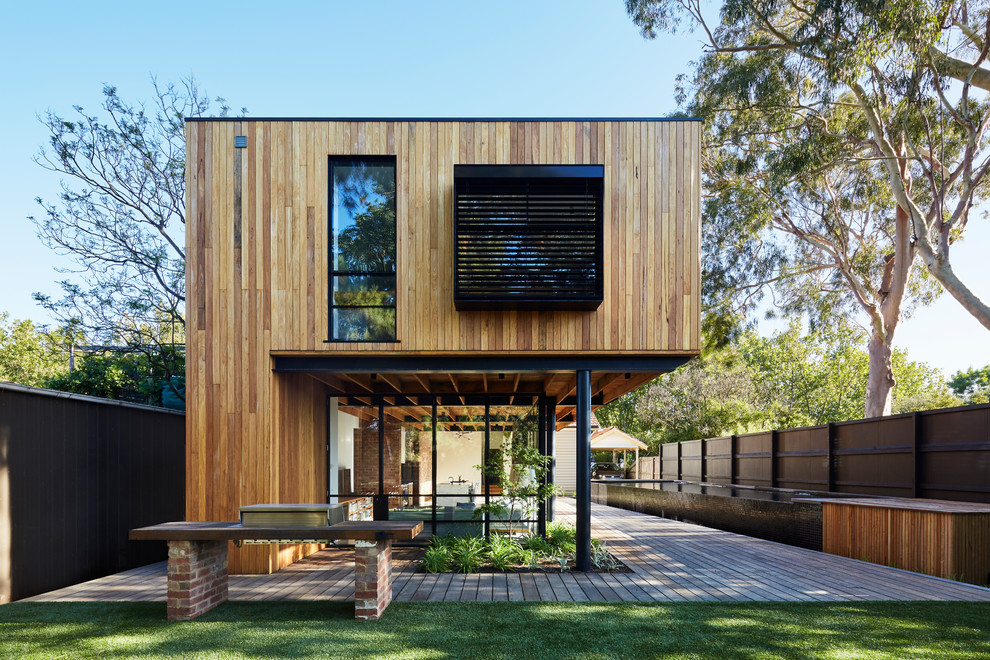 This is an example of a large modern two-storey house exterior in Melbourne with wood siding.