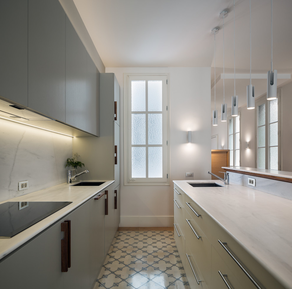 Photo of a contemporary open plan kitchen in Barcelona with an undermount sink, flat-panel cabinets, grey cabinets, marble benchtops and panelled appliances.