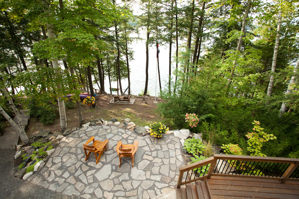 Inspiration for a large country backyard patio in Ottawa with natural stone pavers and no cover.