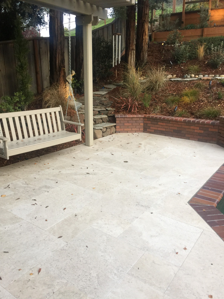 Backyard kitchen with overhead structure, raised garden and stone pavers