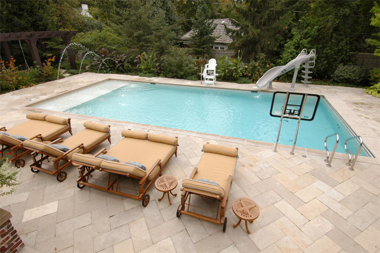 Design ideas for a mid-sized traditional backyard rectangular lap pool in Chicago with natural stone pavers.