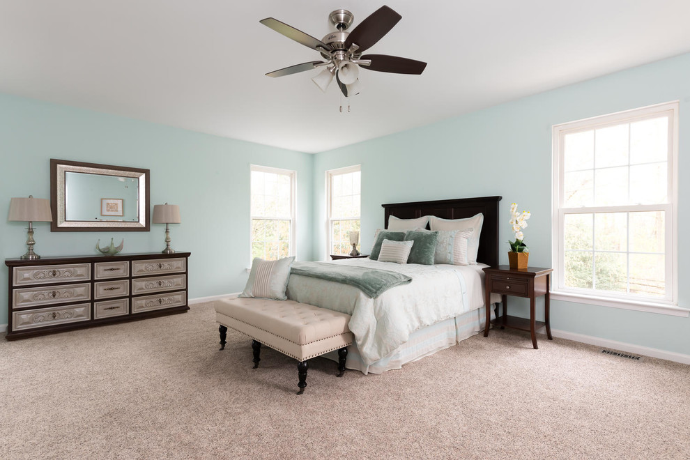 This is an example of a large traditional master bedroom in Philadelphia with blue walls, carpet and beige floor.