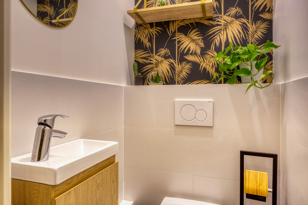 Cette image montre un petit WC suspendu traditionnel avec des portes de placard marrons, un carrelage beige, un mur noir, un sol en carrelage de céramique, un lavabo suspendu, un sol gris, meuble-lavabo suspendu et du papier peint.