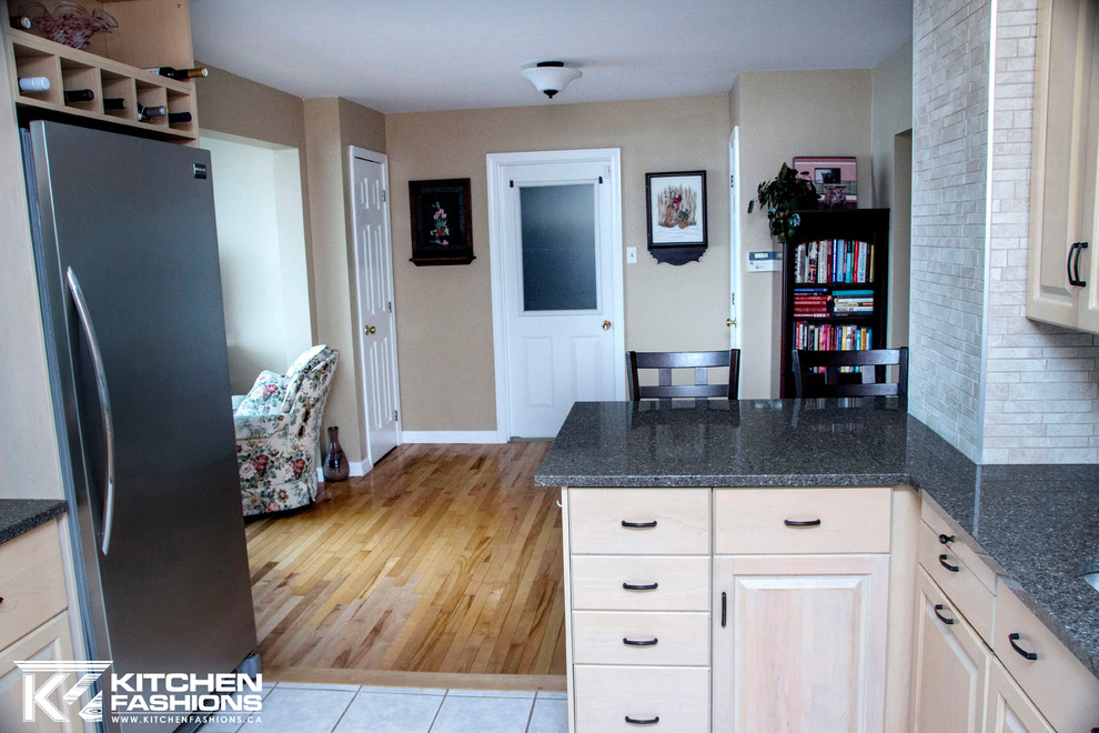 Large trendy u-shaped porcelain tile eat-in kitchen photo with an undermount sink, raised-panel cabinets, light wood cabinets, quartzite countertops, multicolored backsplash, porcelain backsplash, stainless steel appliances and a peninsula