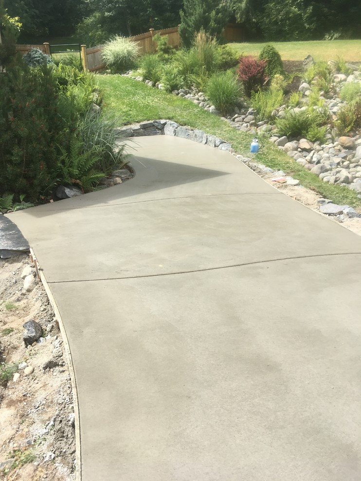 This is an example of a large country backyard patio in Vancouver with concrete slab.