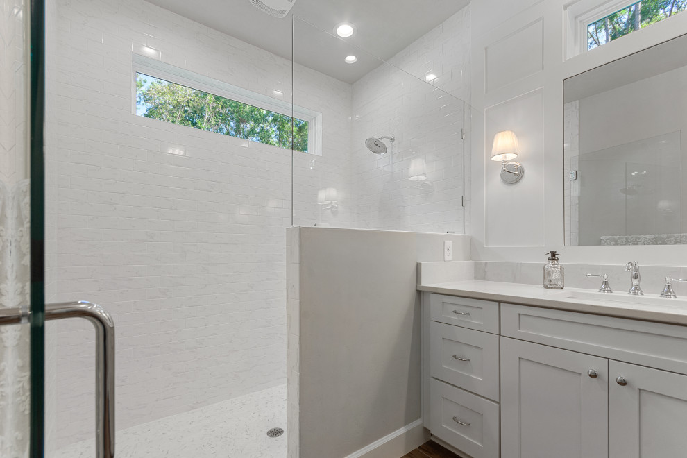 Exempel på ett mellanstort lantligt vit vitt en-suite badrum, med skåp i shakerstil, vita skåp, en dusch i en alkov, en toalettstol med separat cisternkåpa, vit kakel, keramikplattor, grå väggar, klinkergolv i keramik, ett undermonterad handfat, bänkskiva i kvartsit, brunt golv och dusch med gångjärnsdörr