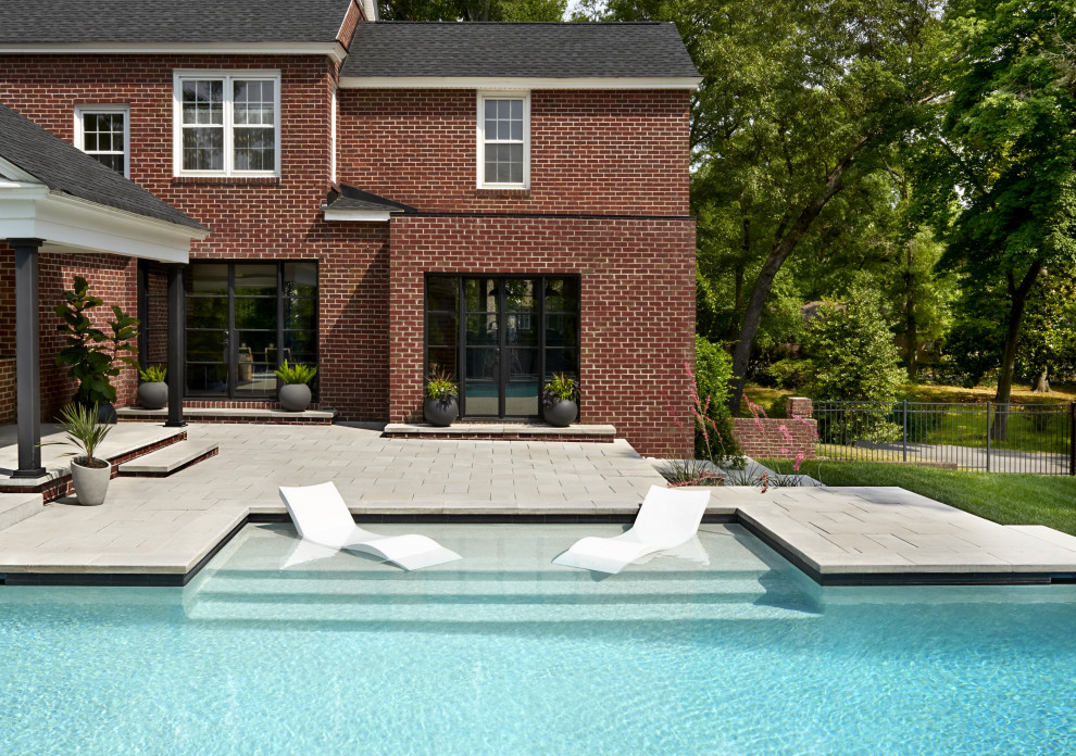 Photo of a backyard pool in Charlotte with concrete pavers.