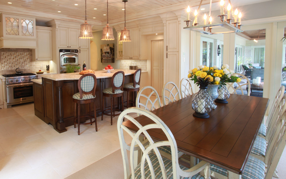 Large transitional l-shaped eat-in kitchen photo in Miami with beige backsplash, subway tile backsplash, stainless steel appliances, raised-panel cabinets, white cabinets, marble countertops and an island