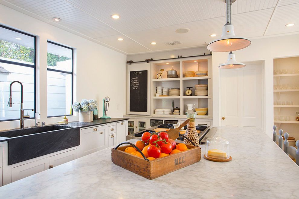 Photo of an eclectic kitchen in Los Angeles with an integrated sink, marble benchtops, open cabinets and white cabinets.